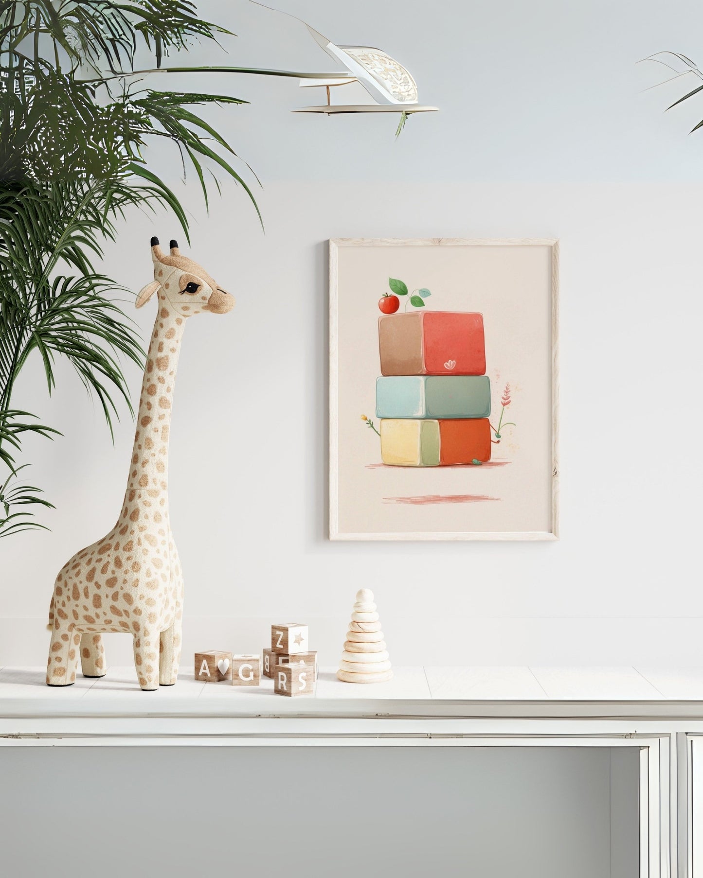 Poster con poligoni geometrici in cornice sopra mobile bianco con giraffa decorativa.
