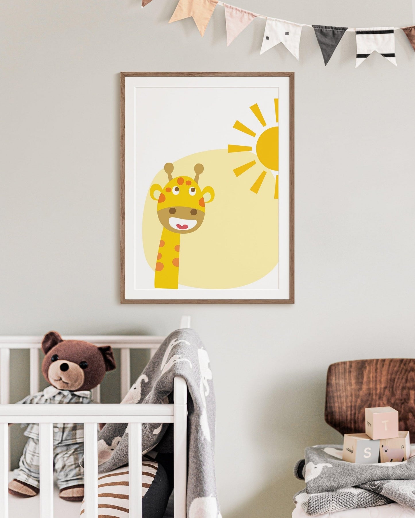 Poster con giraffa sorridente sotto il sole appeso in cameretta, sopra la culla con peluche orsetto e decorazioni allegre.