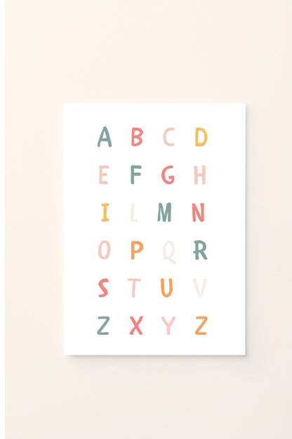 Poster educativo con alfabeto colorato in lettere maiuscole, su sfondo rosato, perfetto per decorare la cameretta e aiutare i bambini a imparare le lettere in modo giocoso e armonioso.