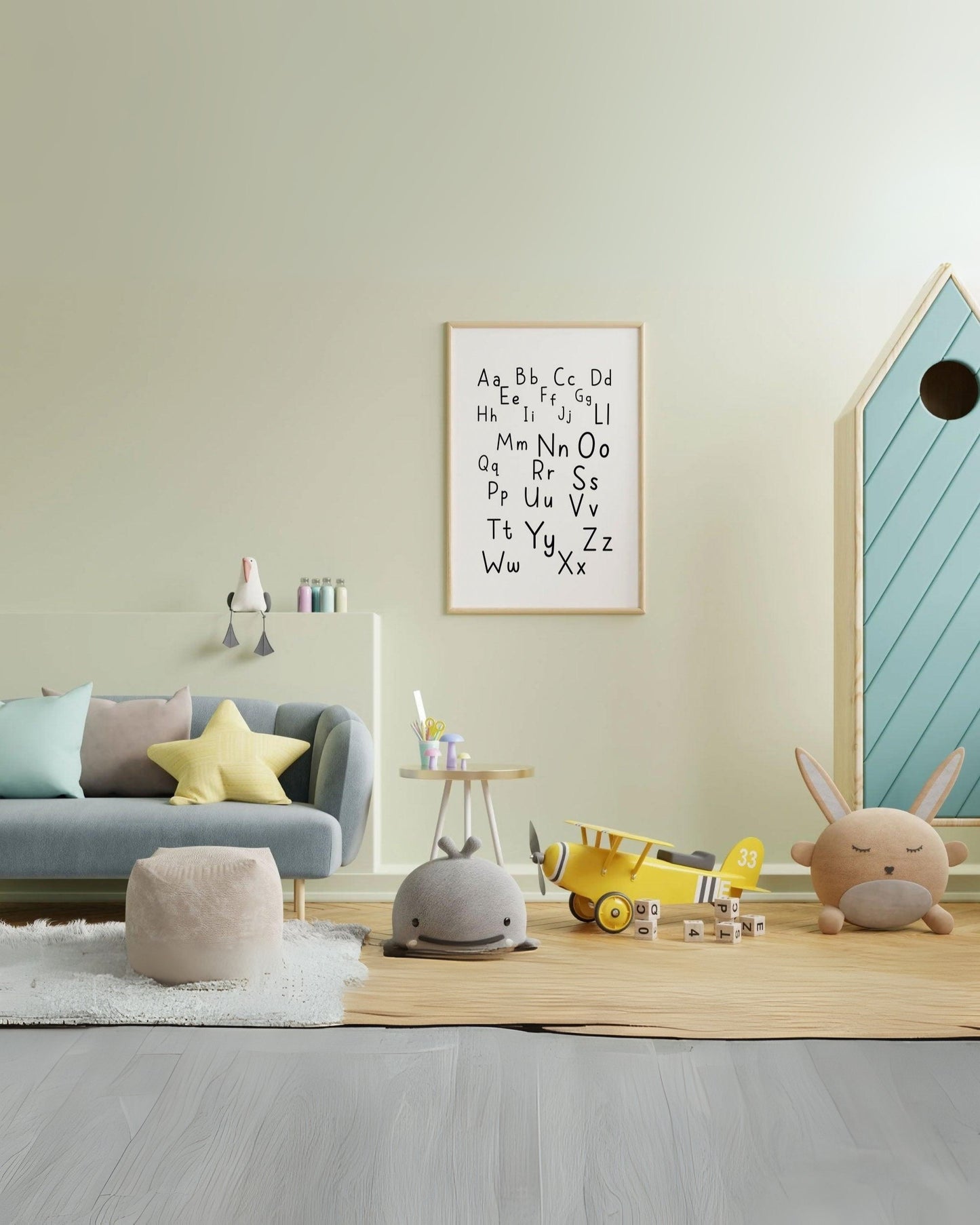 Poster alfabetico con lettere maiuscole e minuscole, appeso in cameretta colorata con divanetto, peluche e giochi sul tappeto.