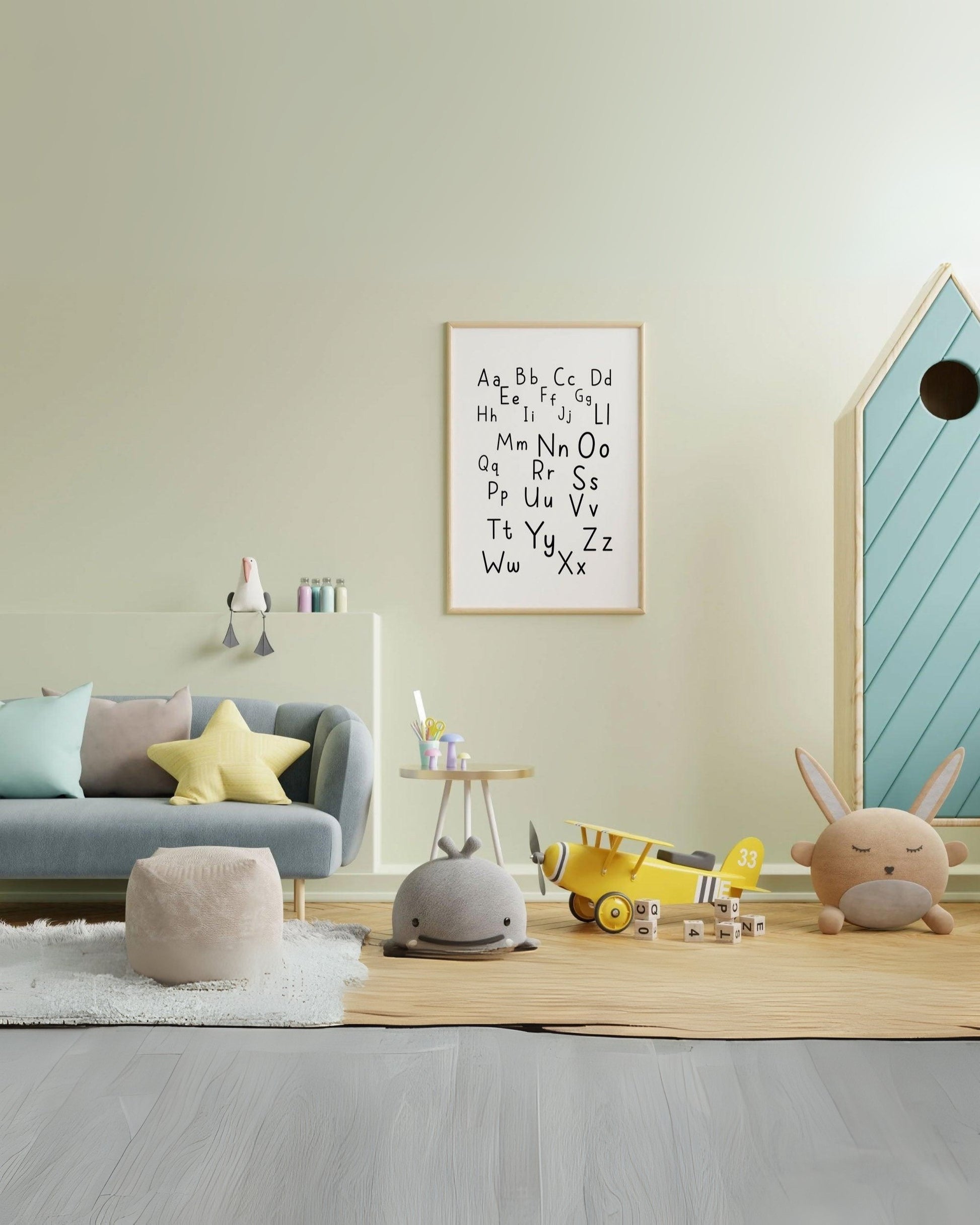 Poster alfabetico con lettere maiuscole e minuscole, appeso in cameretta colorata con divanetto, peluche e giochi sul tappeto.