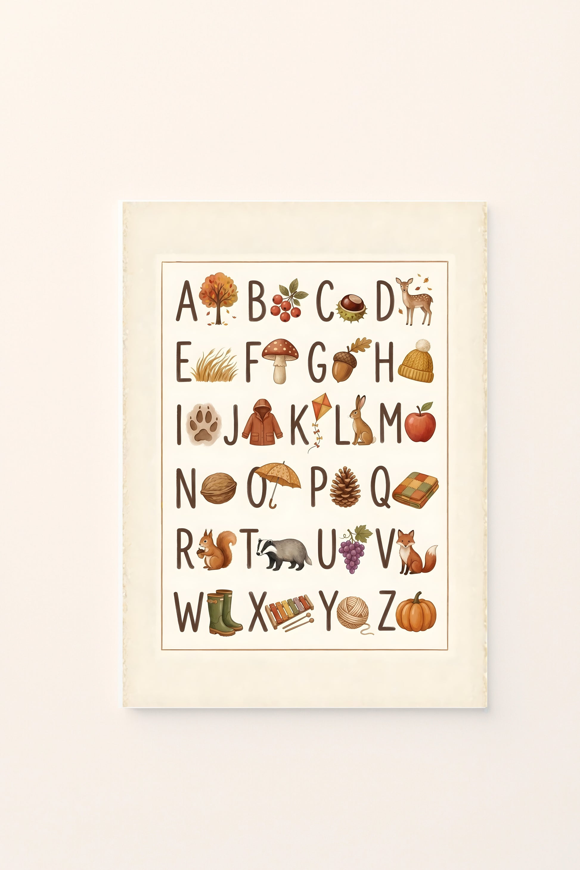 Poster per bambini con alfabeto illustrato e immagini autunnali associate alle lettere, tra animali, frutti, foglie e oggetti della stagione, presentato su sfondo rosato.