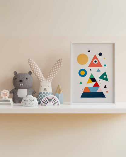 Poster per bambini con forme geometriche colorate, cornice bianca, accanto a peluche coniglio a pois.