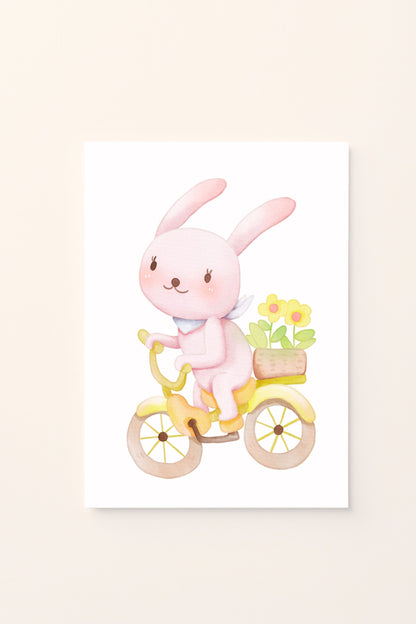 Poster illustrato con coniglietto in bicicletta e cestino di fiori su sfondo rosato, ideale per decorare la cameretta dei bambini con un’immagine dolce e primaverile.