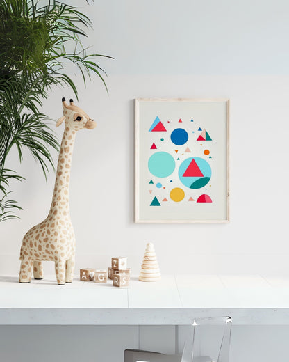 Poster con forme geometriche colorate appeso in una cameretta, accanto a una giraffa di peluche e giochi educativi.