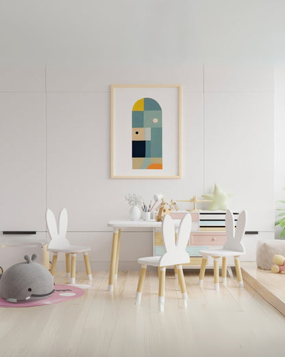 Poster geometrico in cornice appeso in sala giochi con tavolino e sedie bianche