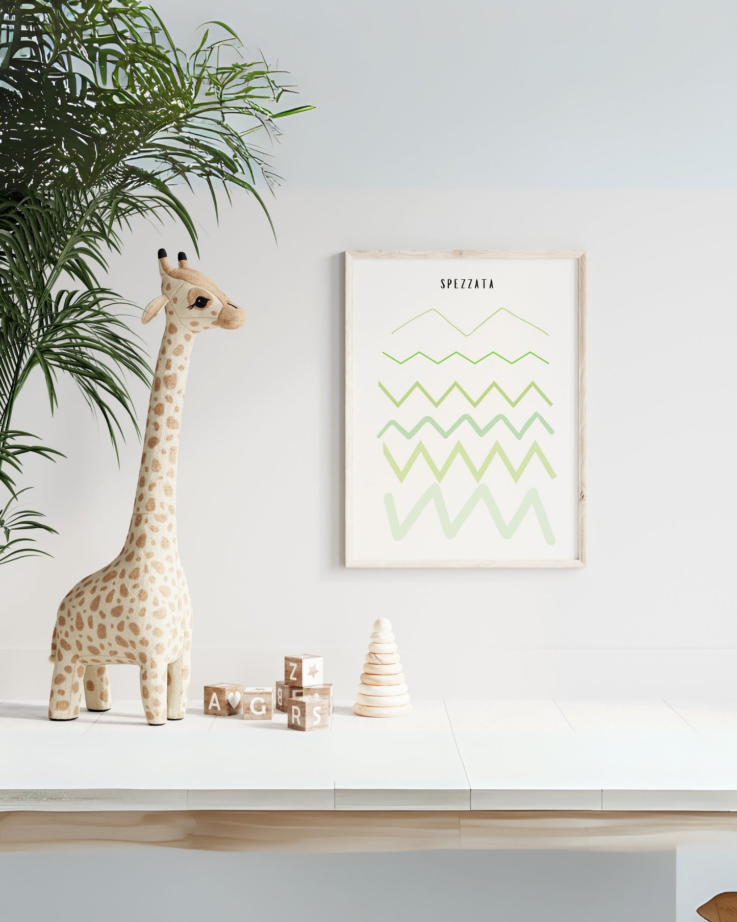 Poster educativo con linea spezzata verde in cornice chiara, esposto in cameretta con giraffa di peluche e giochi in legno.