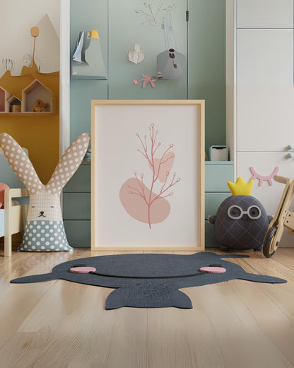 Poster digitale con fiori stilizzati e forme rosa astratte, incorniciato e appoggiato sul pavimento in una cameretta colorata con peluche e decorazioni.